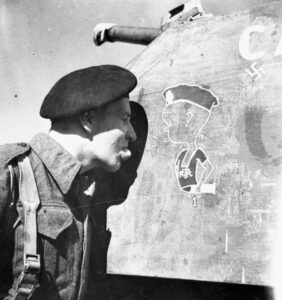 Lucera - Lance Corporal M. R. Leonard examining the Little Henry painting on a Sherman tank of the Three Rivers Regiment