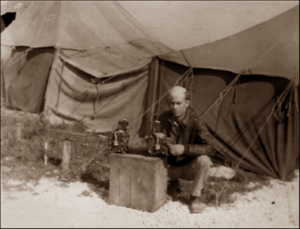 Lucera - T Sgt. Clarence W. Fleming Wenston Wyo at a line tent inspecting spare parts 05-1945